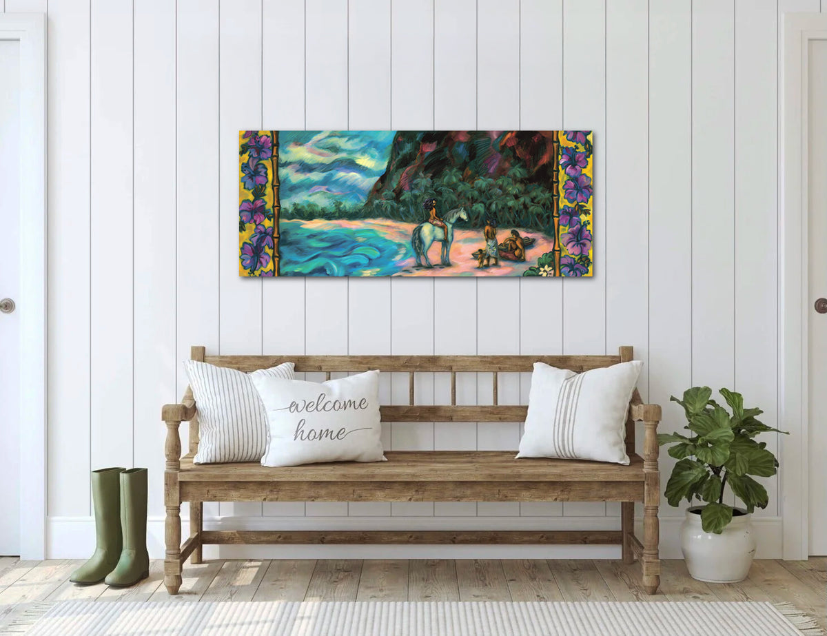 A colorful landscape canvas print (Ohana) featuring a beach scene with figures and purple floral borders, displayed on a white paneled wall above a wooden bench with decorative pillows.