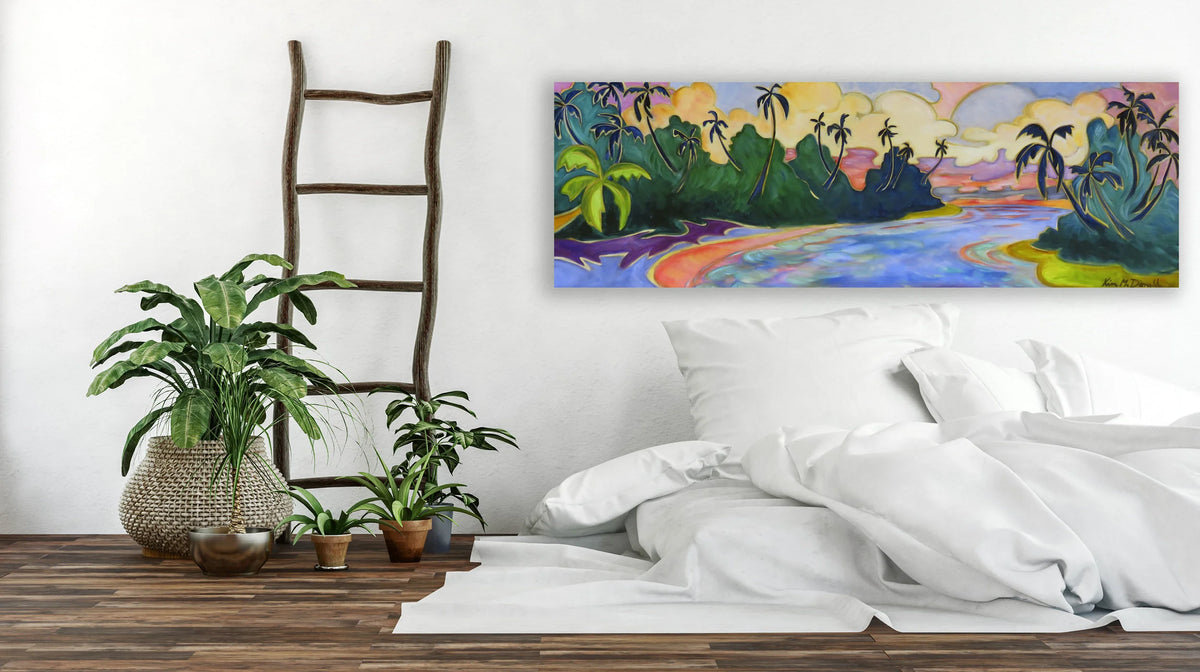 A colorful landscape wall art print depicting a tropical island scene with palm trees, a winding river, and a sunset sky, displayed above a bed in a styled bedroom setting.